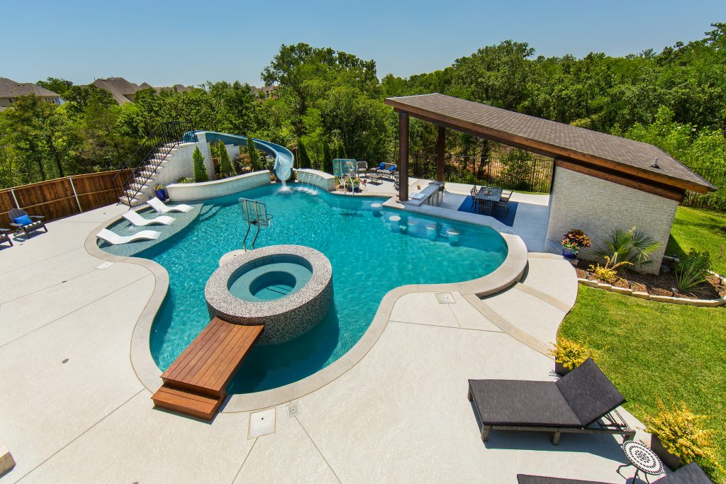 freeform pool with slide, hot tub, sun loungers